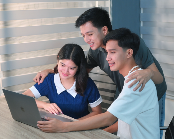 Teenagers looking at a laptop together
